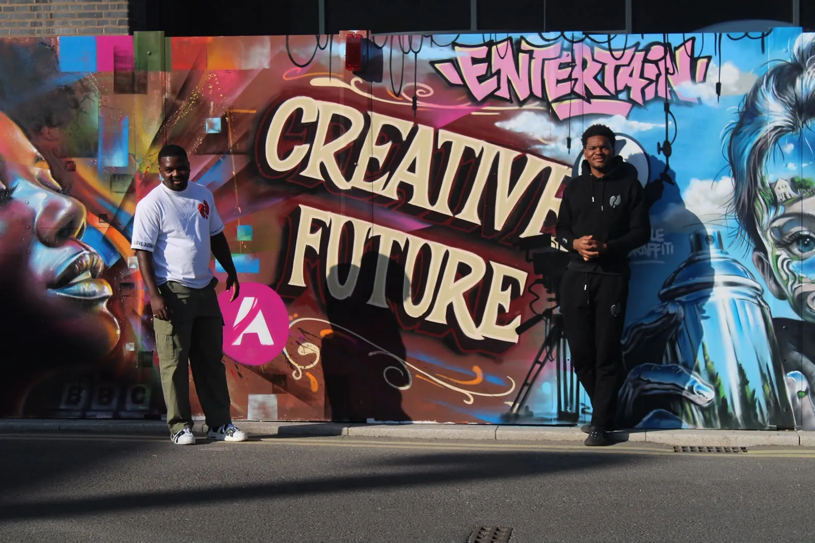 Two LVOE wearers photographed in front of a Creative Future graffiti mural